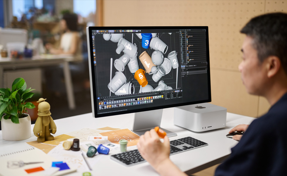 Um designer utiliza o Mac para renderização 3D.